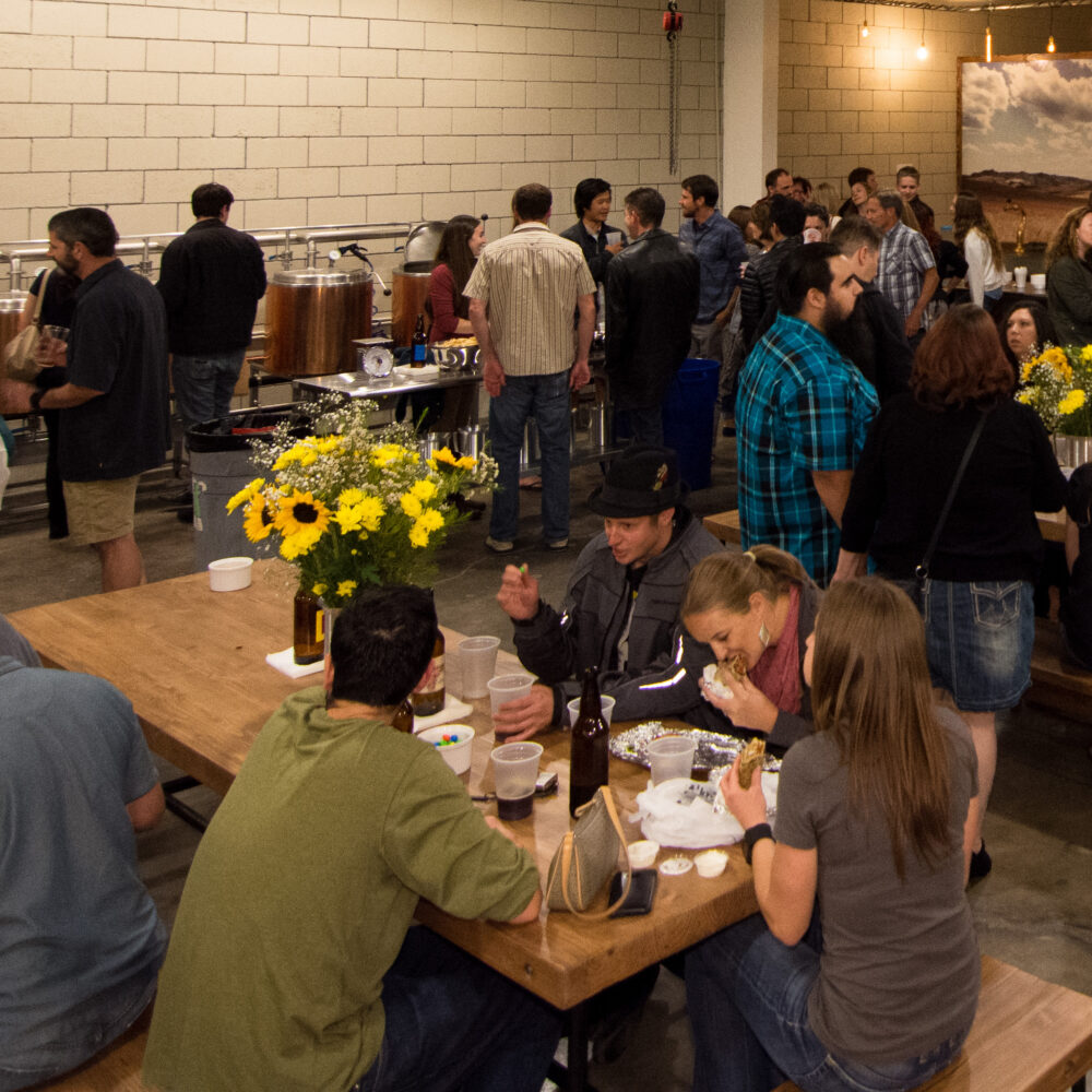 Image is of a group of people at a party at the brewery
